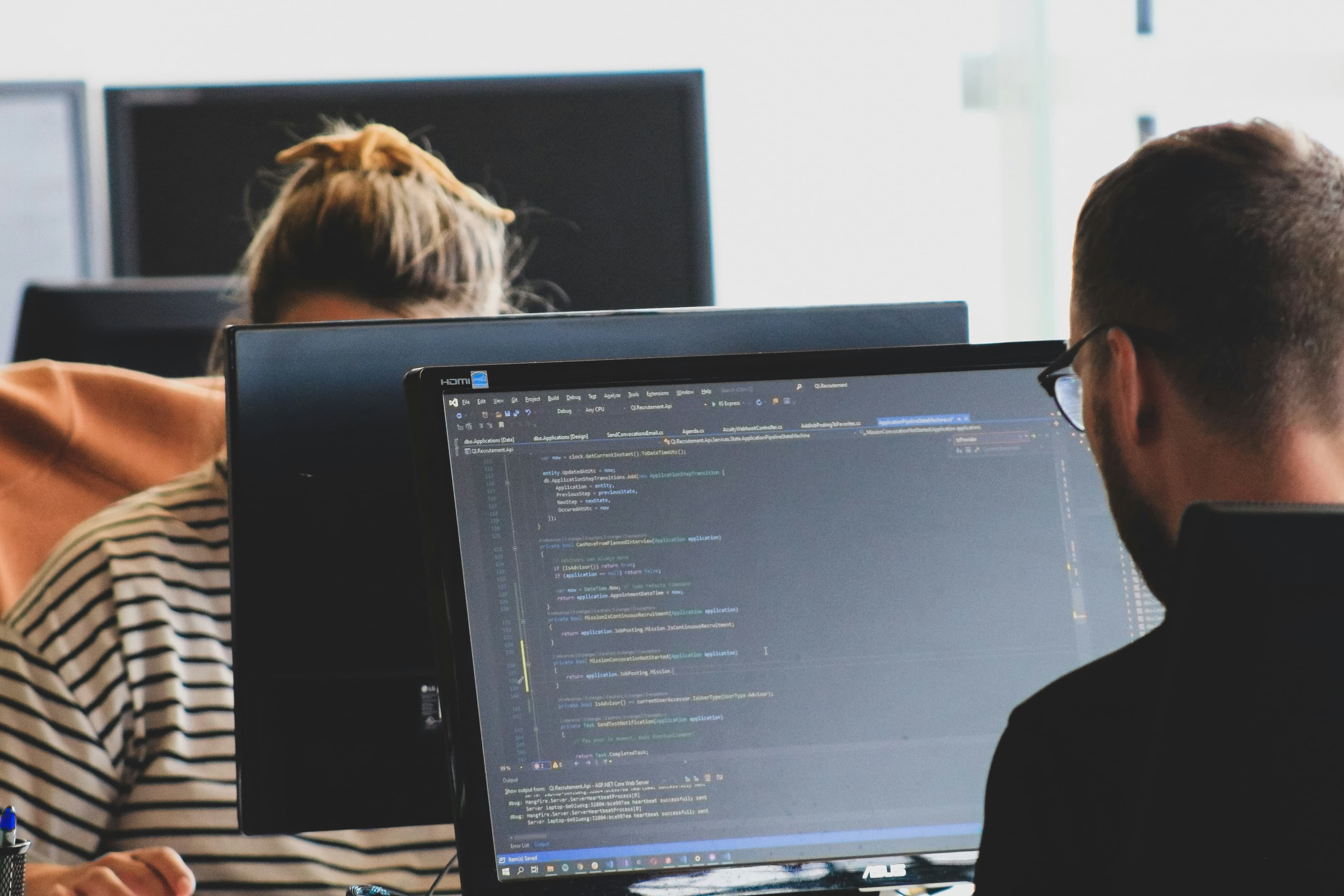 Profissionais trabalhando em projeto digital diante de monitores